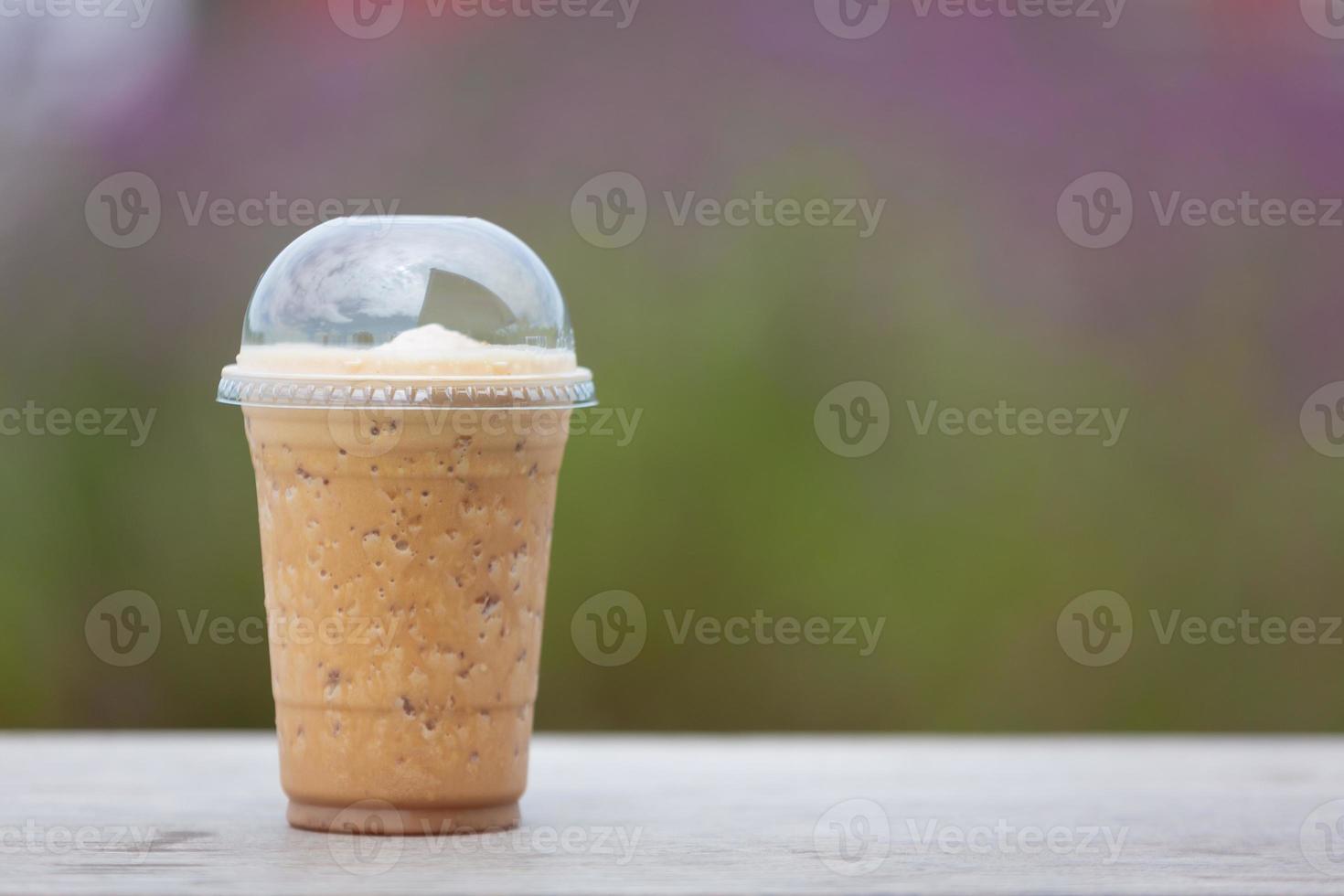 des shakes de café sont placés sur une table en bois dans le jardin fleuri. photo