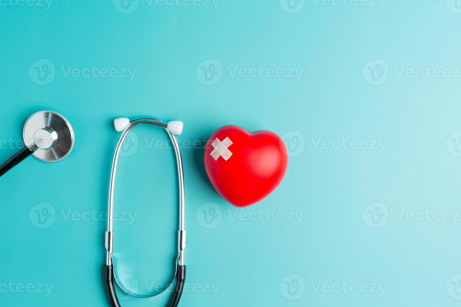 coeur rouge et stéthoscope sur fond bleu pensant la journée du pharmacien photo