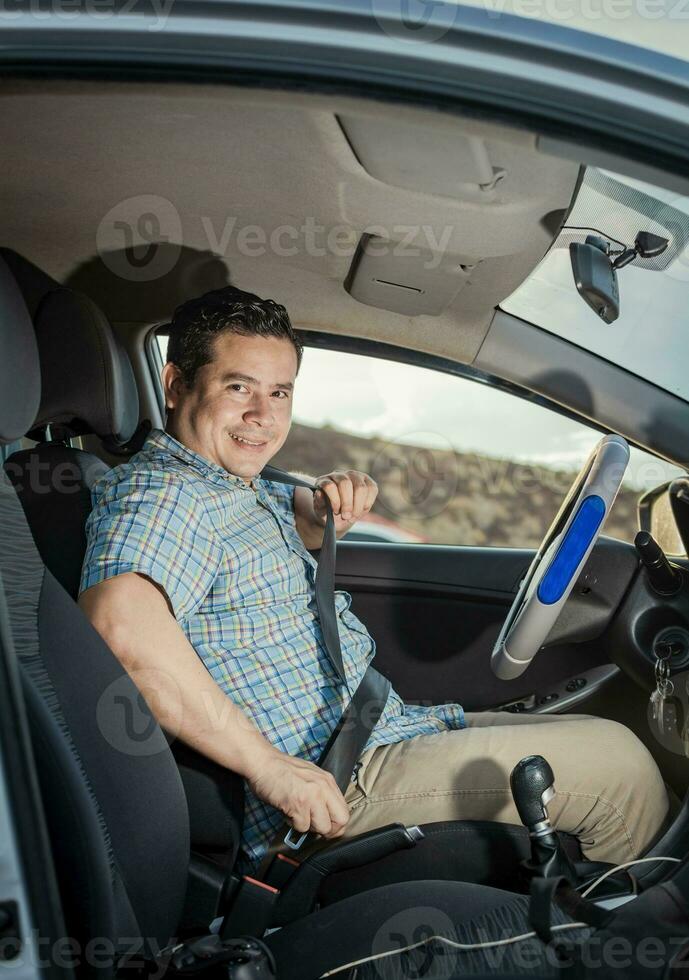 content chauffeur en mettant sur le sien siège ceinture, souriant Masculin chauffeur en mettant sur le sien siège ceinture. concept de une chauffeur dans le sien voiture en mettant sur le sien siège ceinture. souriant la personne en mettant sur siège ceinture photo