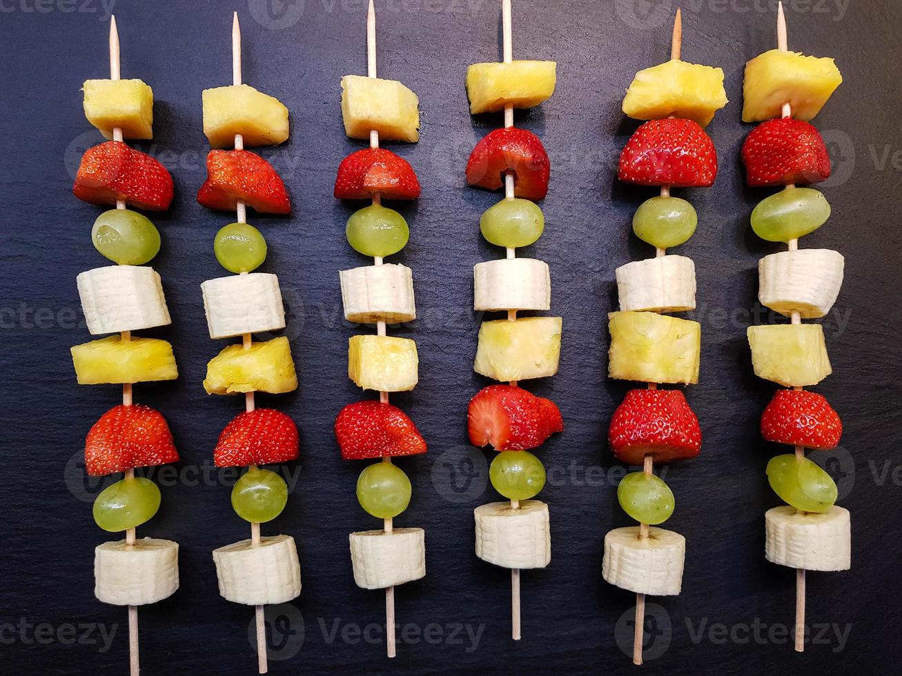 différents fruits sur une brochette recouverte de chocolat photo