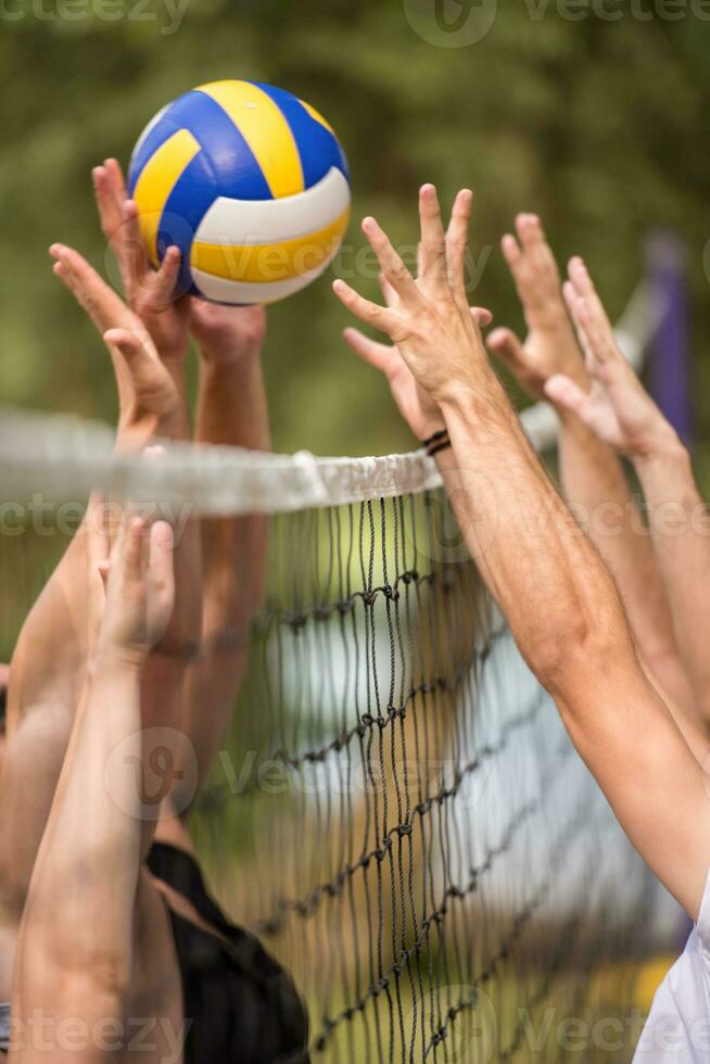 groupe de jeunes amis jouant au beach-volley photo