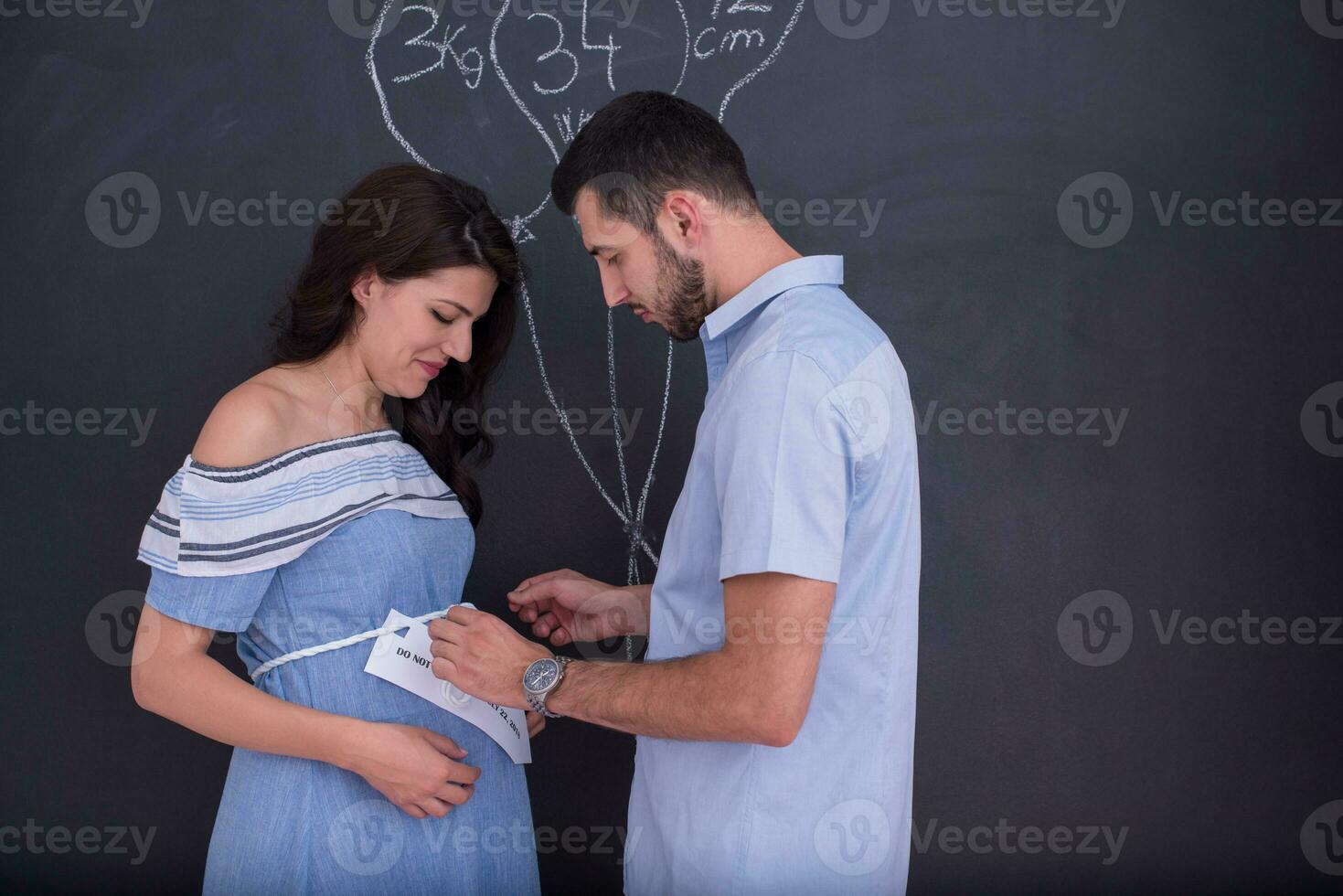 Couple enceinte dessinant leur imagination sur tableau noir photo