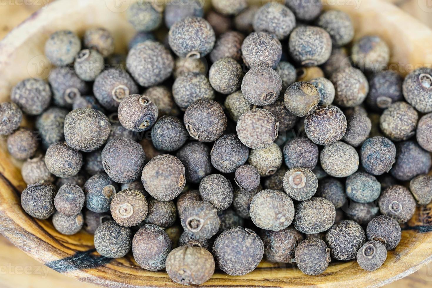 quelques boules de piment de la Jamaïque sur bois d'olivier photo