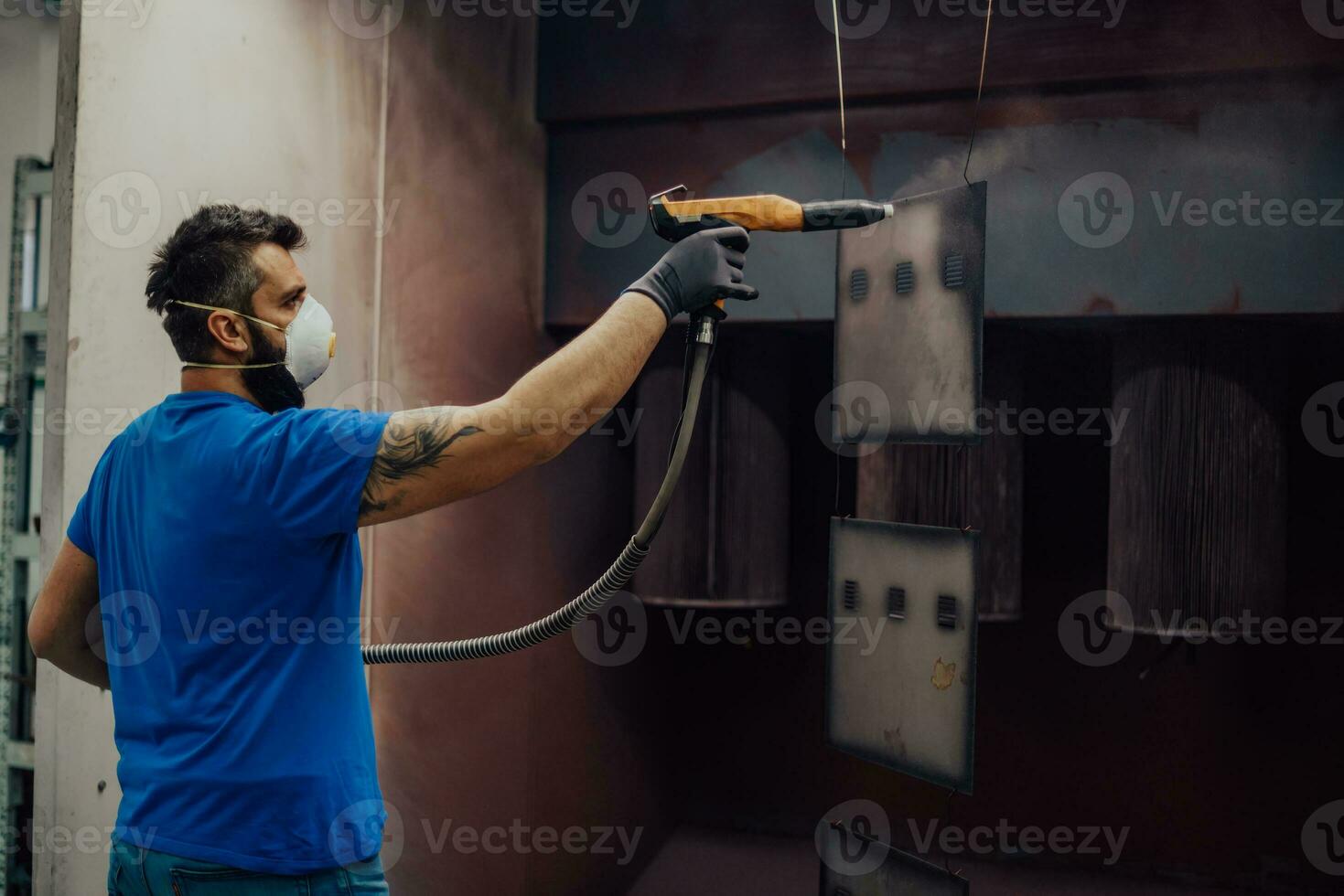 le peintre peint l'élément de fer. pièces de peinture industrielle. dessins en métal photo