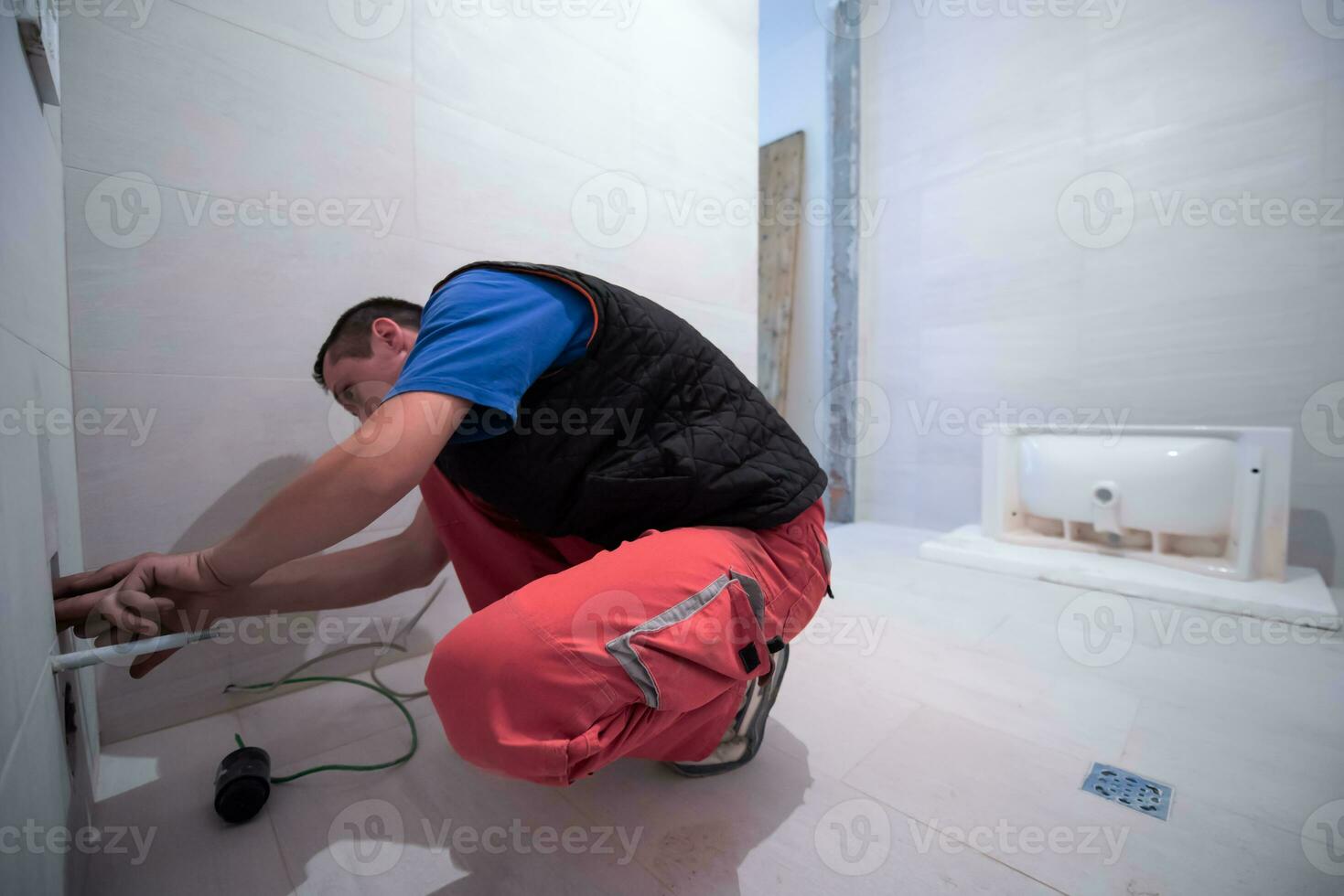 plombier professionnel travaillant dans une salle de bain photo