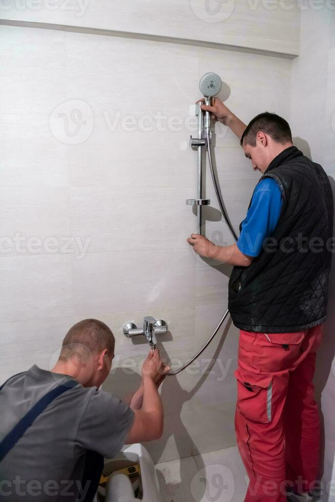 professionnel plombiers travail dans une salle de bains photo