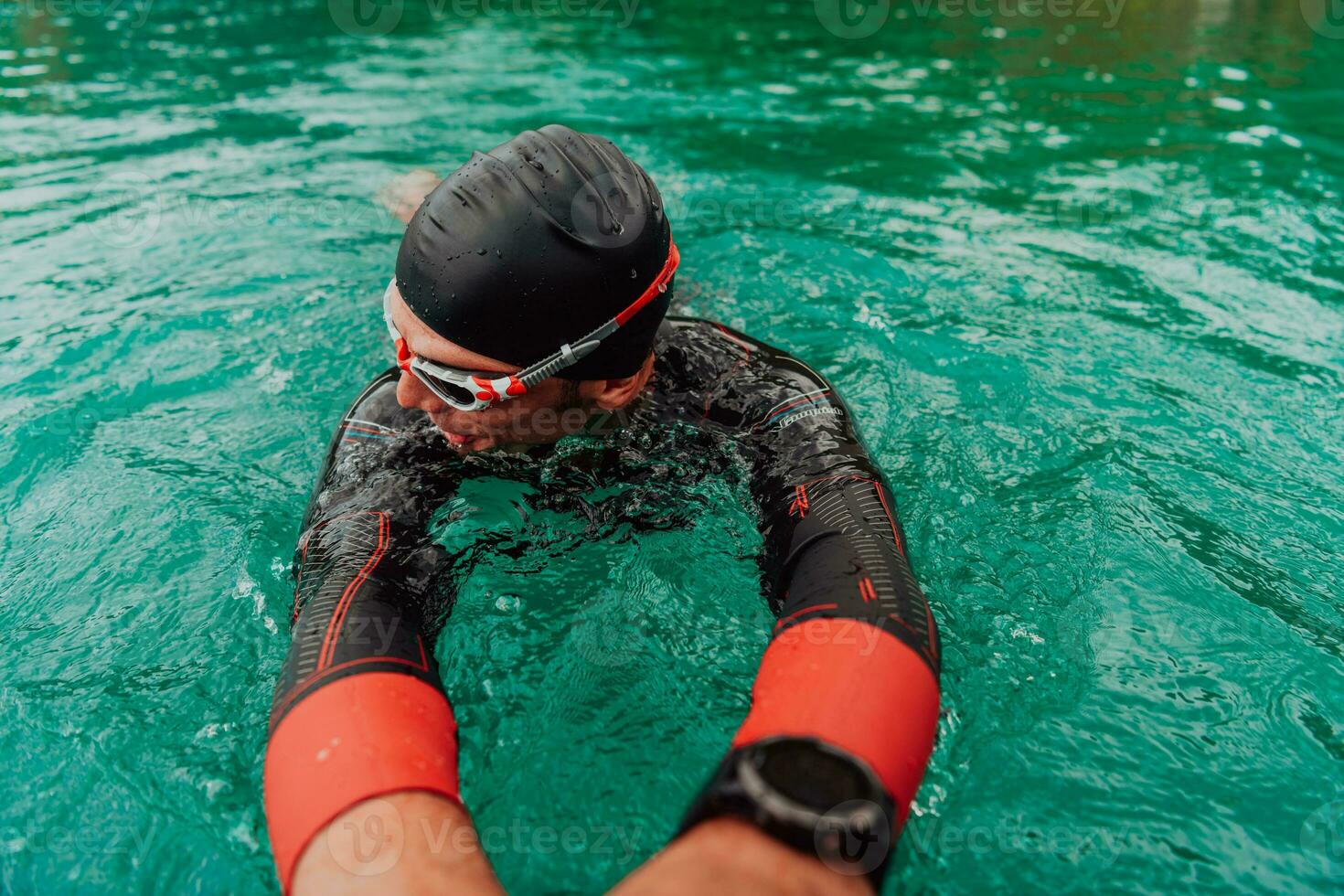 une triathlète dans une professionnel nager costume les trains sur le rivière tandis que en train de préparer pour olympique nager photo