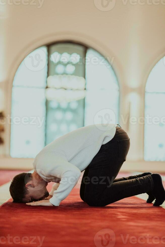 une musulman prier dans une moderne mosquée pendant le saint musulman mois de Ramadan photo