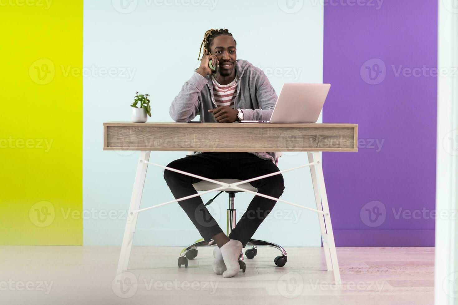 souriant Jeune africain homme pigiste en utilisant portable et téléphone intelligent en train d'étudier en ligne travail de Accueil photo