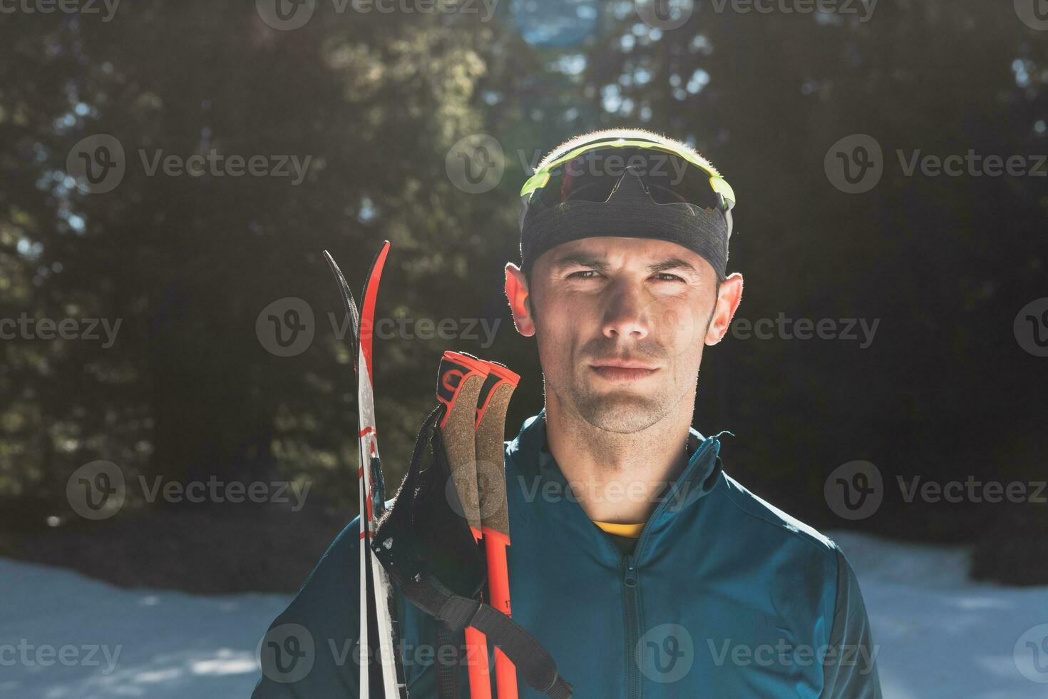 portrait Beau Masculin athlète avec traverser pays des skis dans mains et des lunettes de protection, formation dans neigeux forêt. en bonne santé hiver mode de vie concept. photo