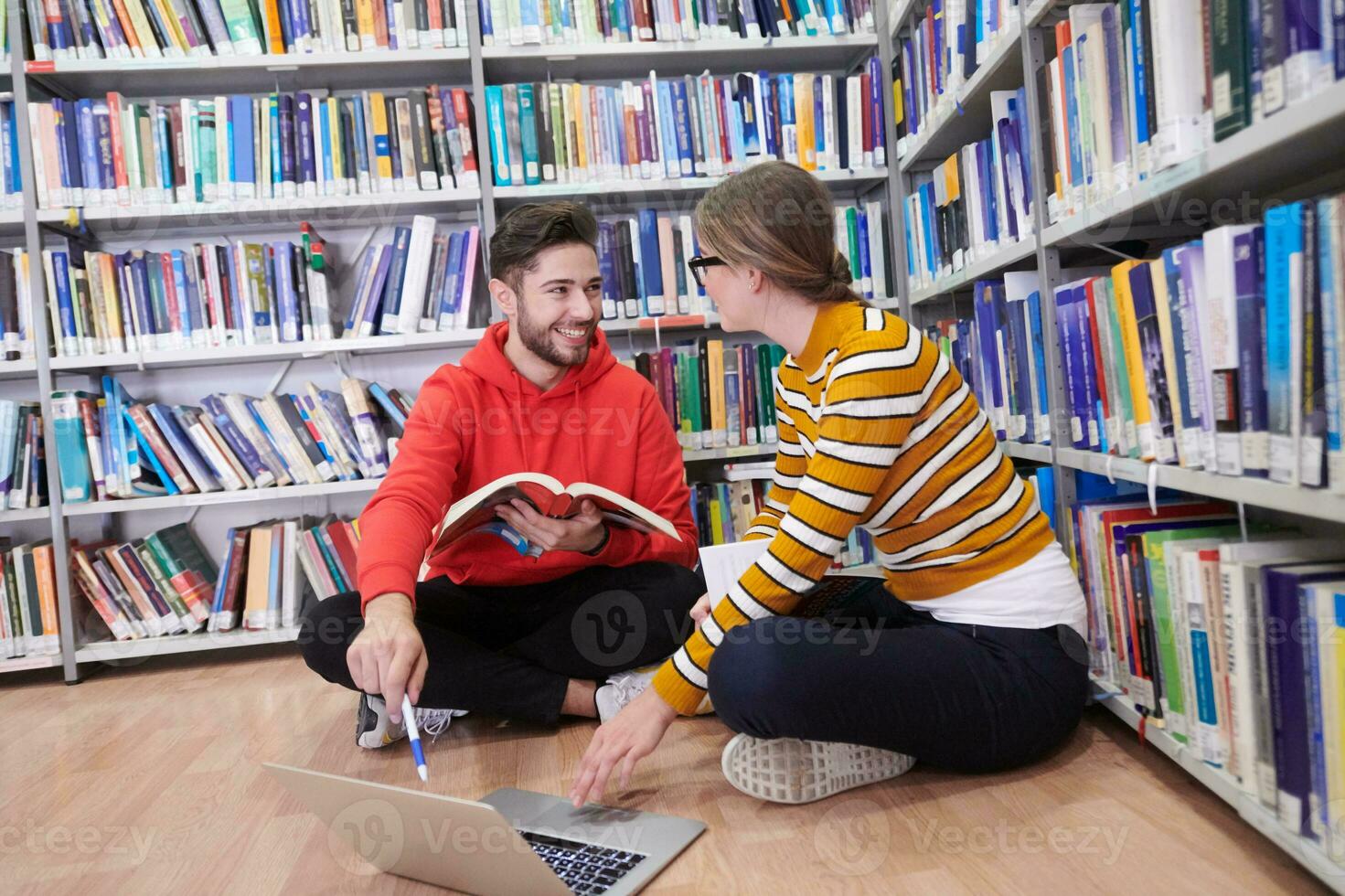 les élèves utilisent un cahier, un ordinateur portable et une bibliothèque scolaire photo