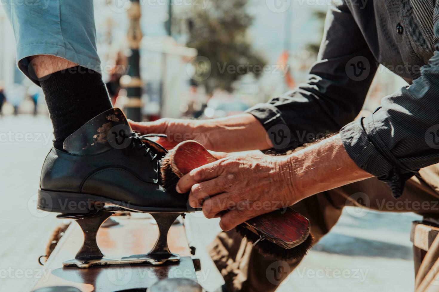 un vieux homme main polissage et La peinture une noir chaussure à rue photo