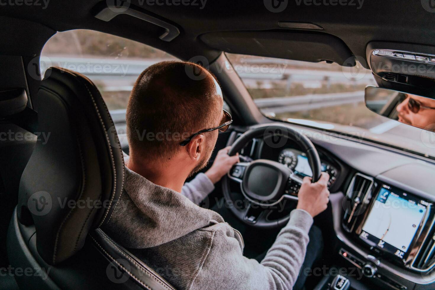 une homme avec une des lunettes de soleil conduite une voiture à le coucher du soleil. le concept de voiture Voyage photo