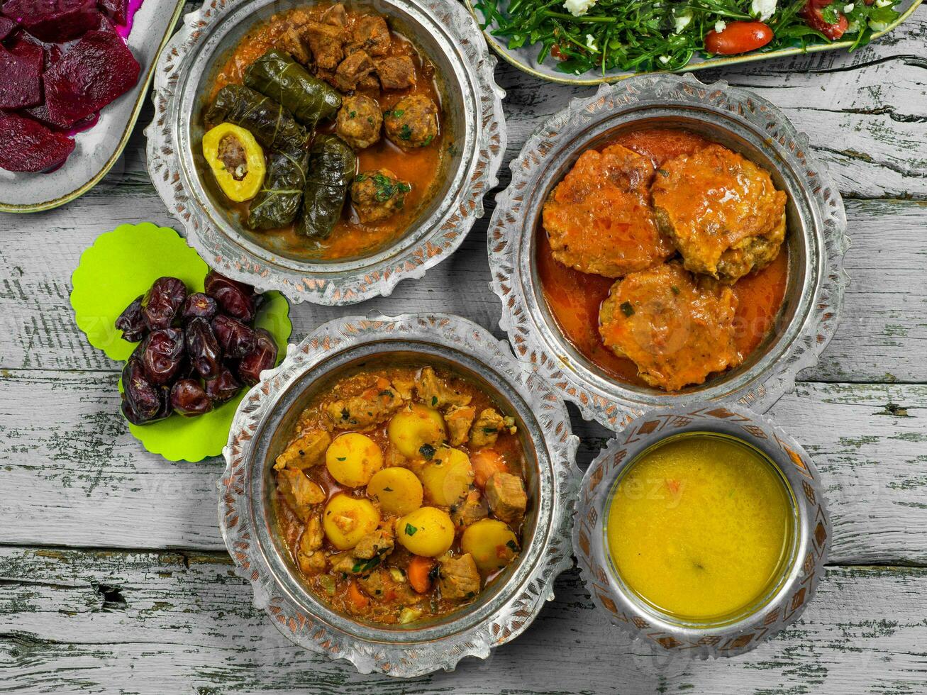 eid mubarak traditionnel Ramadan iftar dîner. assorti savoureux nourriture dans authentique rustique vaisselle sur en bois bleu Contexte. turc bosniaque nourriture Viande kebab, Pita, sarma, klepe, sogan dolma. photo