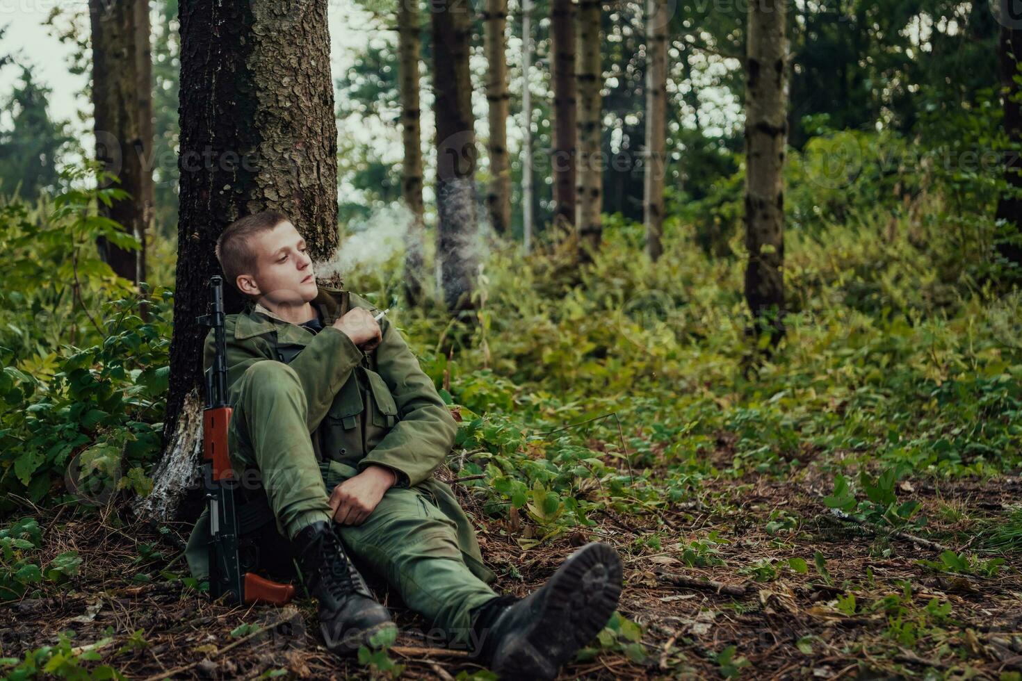 terroriste avoir une Pause et fumée cigarette dans forêt pendant bataille photo