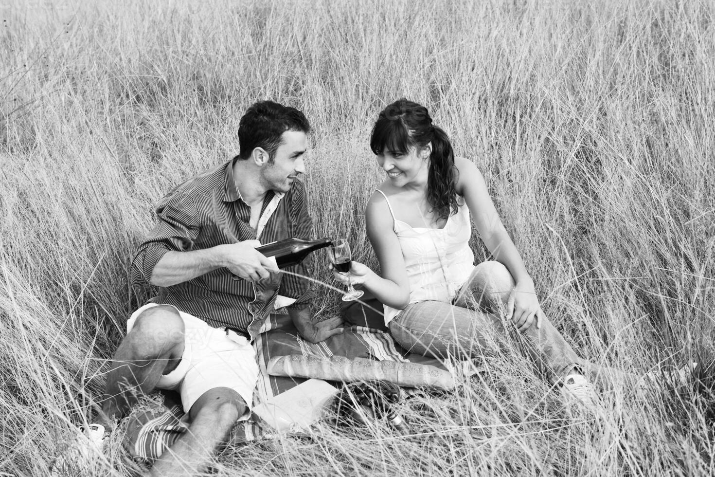 couple heureux profitant d'un pique-nique à la campagne dans l'herbe haute photo