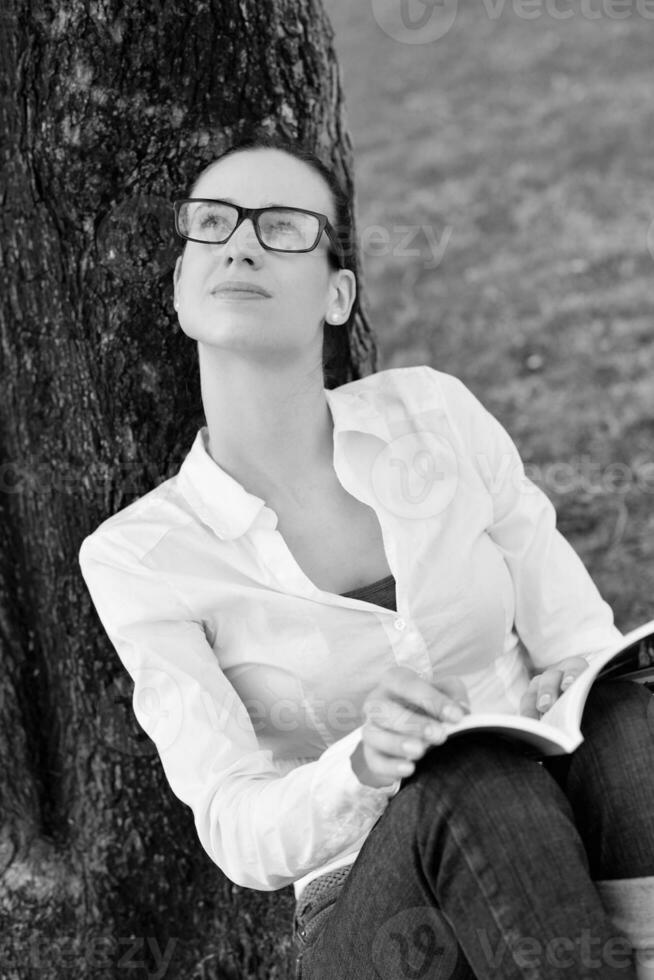 jeune femme lisant un livre dans le parc photo