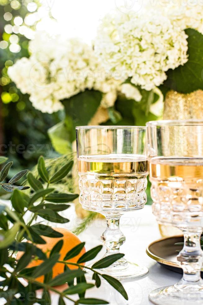 vin rosé dans des verres. vin rose sur fond de bouteilles dorées photo