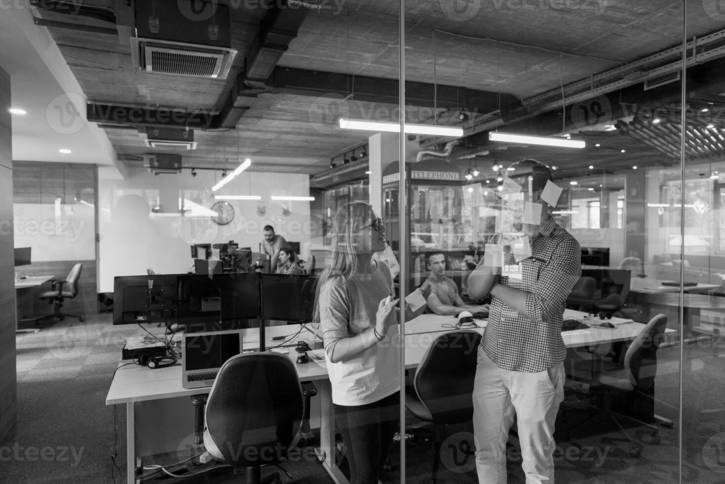 jeune couple à l'intérieur d'un bureau moderne écrivant des notes sur des autocollants photo