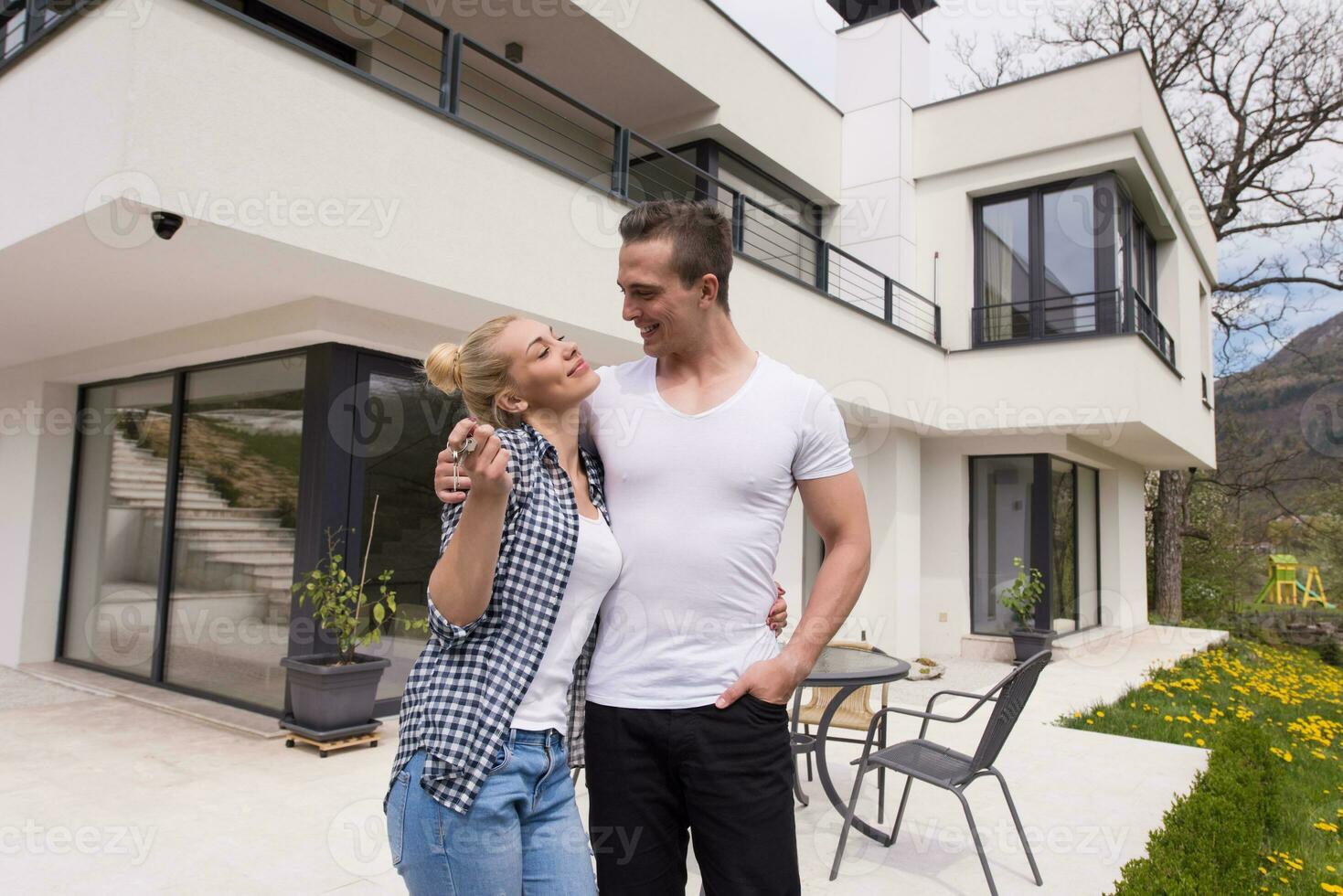 couple s'embrassant devant une nouvelle maison de luxe photo