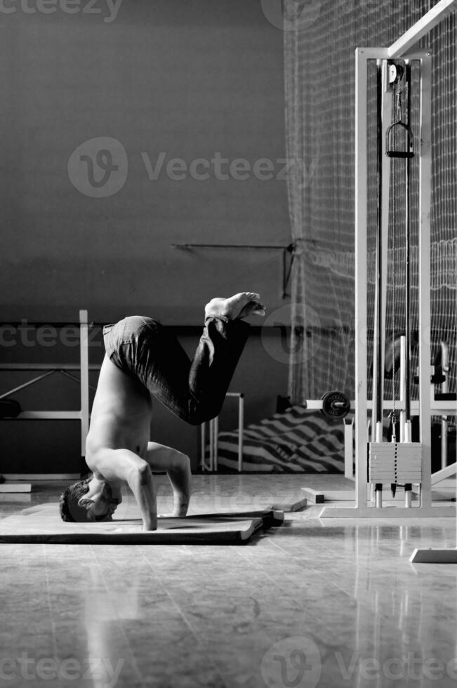 jeune homme faisant le poirier dans un studio de remise en forme photo