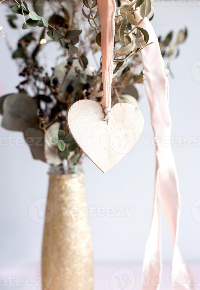 pendentif coeur en bois clair sur un ruban de soie rose. photo