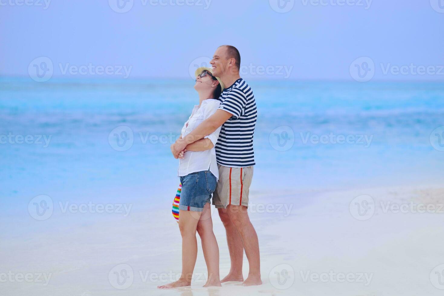 heureux jeune couple s'amuser sur la plage photo