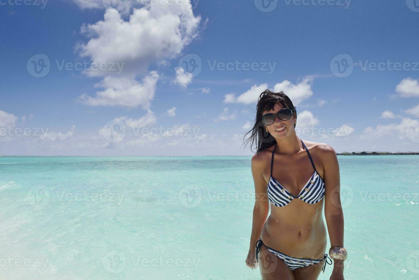 belle jeune femme sur la plage s'amuser et se détendre photo