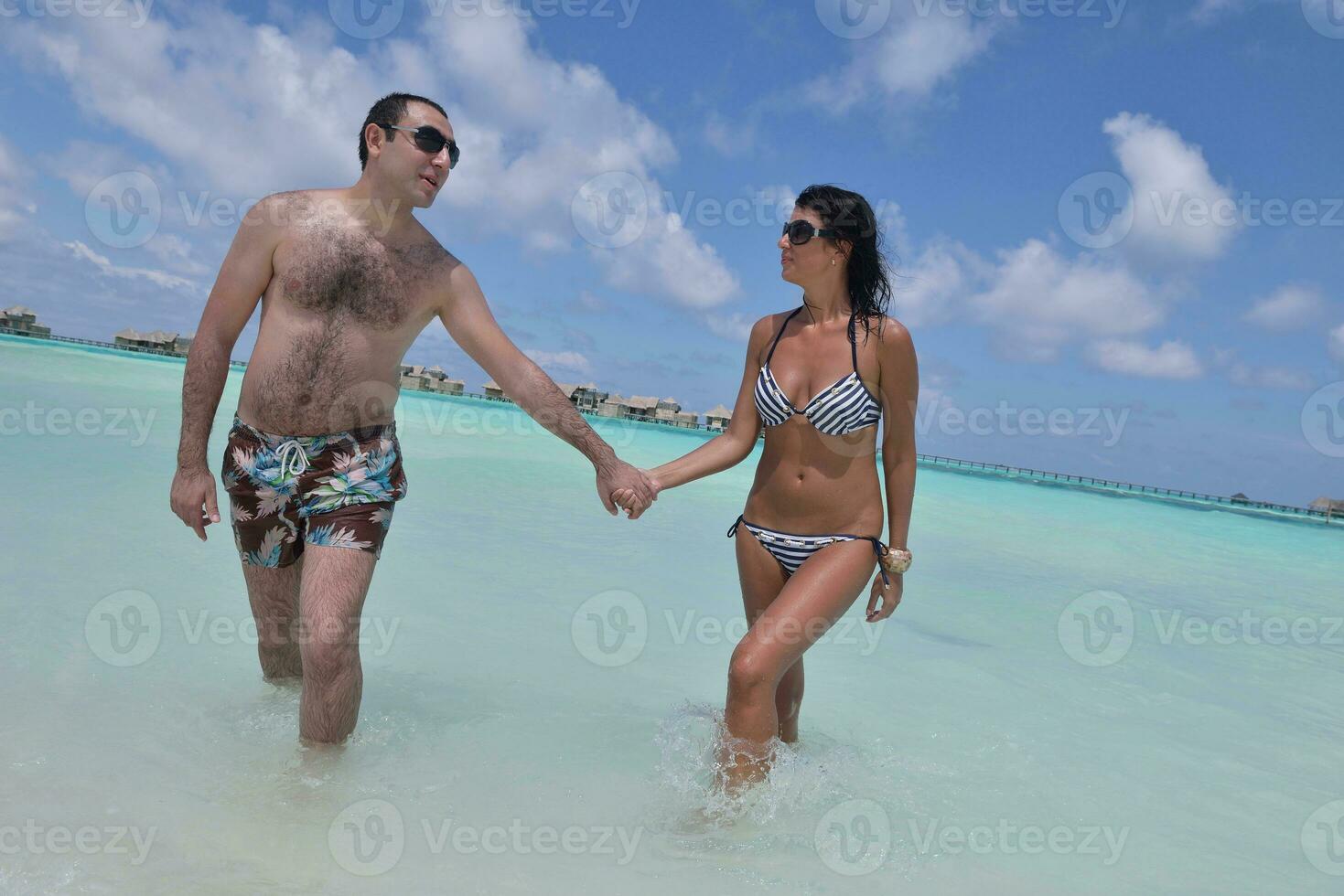 heureux jeune couple s'amuser sur la plage photo