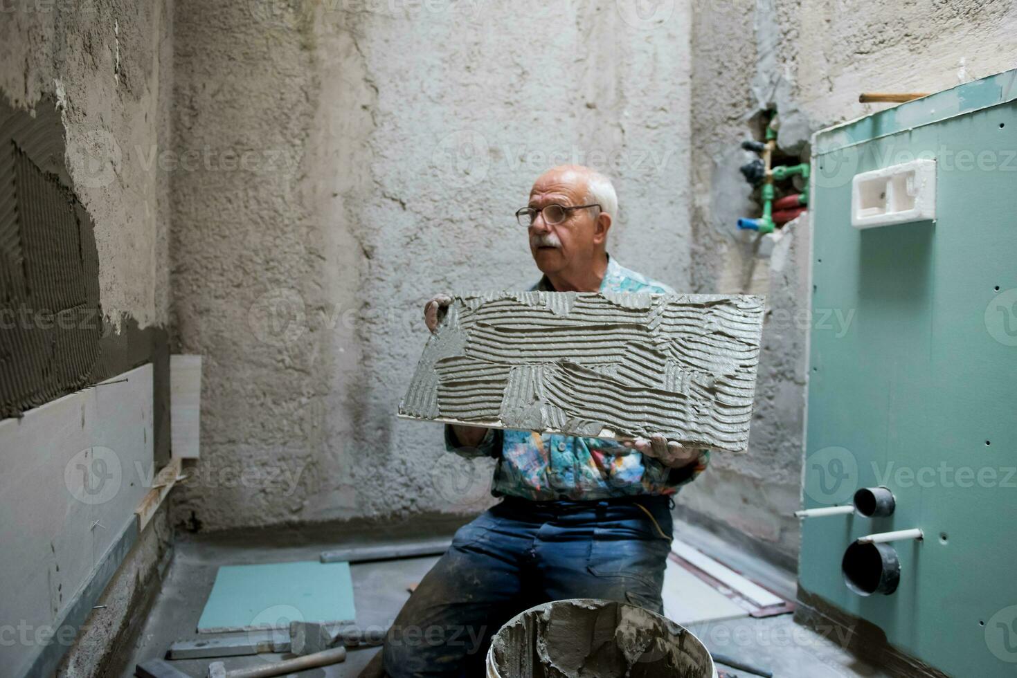 travailleur installant de grands carreaux de céramique photo