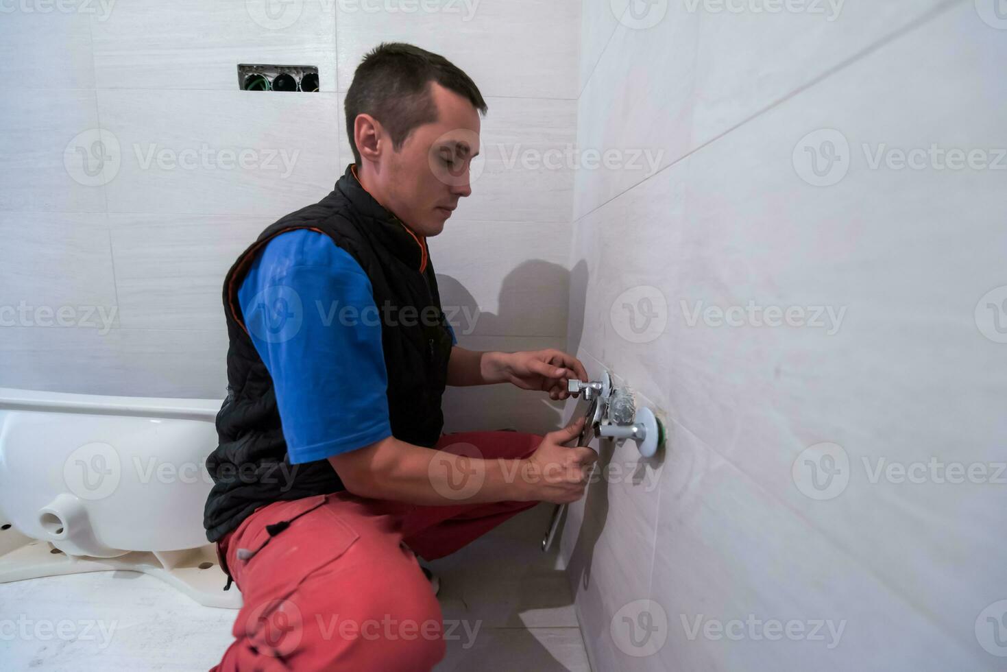 plombier professionnel travaillant dans une salle de bain photo