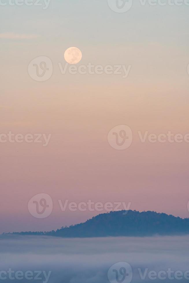 la pleine lune tombant et la brume du matin. photo