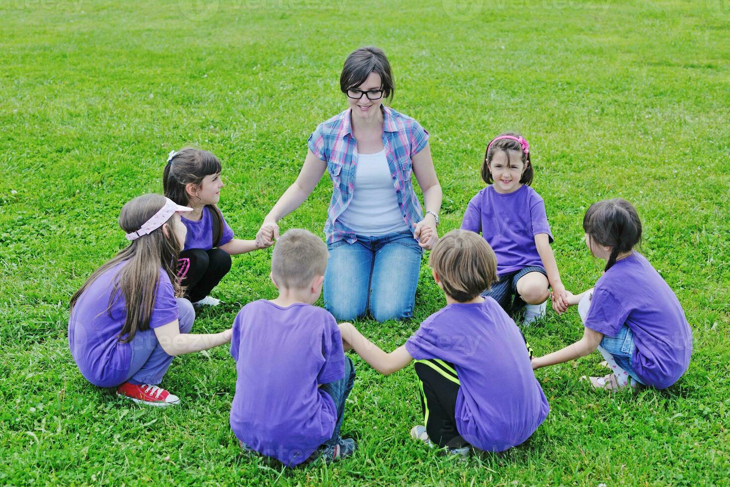 groupe d'enfants heureux avec professeur dans la nature photo