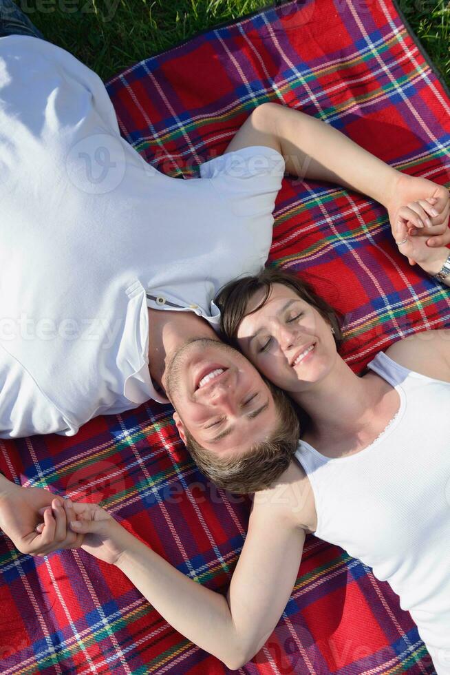 heureux jeune couple ayant un pique-nique en plein air photo
