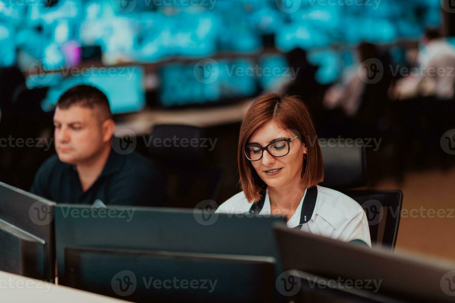 femelle Sécurité opérateur travail dans une Les données système contrôle pièce des bureaux technique opérateur travail à poste de travail avec plusieurs affiche, Sécurité garde travail sur plusieurs moniteurs photo