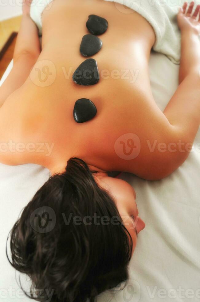 belle femme se faire masser aux pierres chaudes au spa et centre de bien-être photo