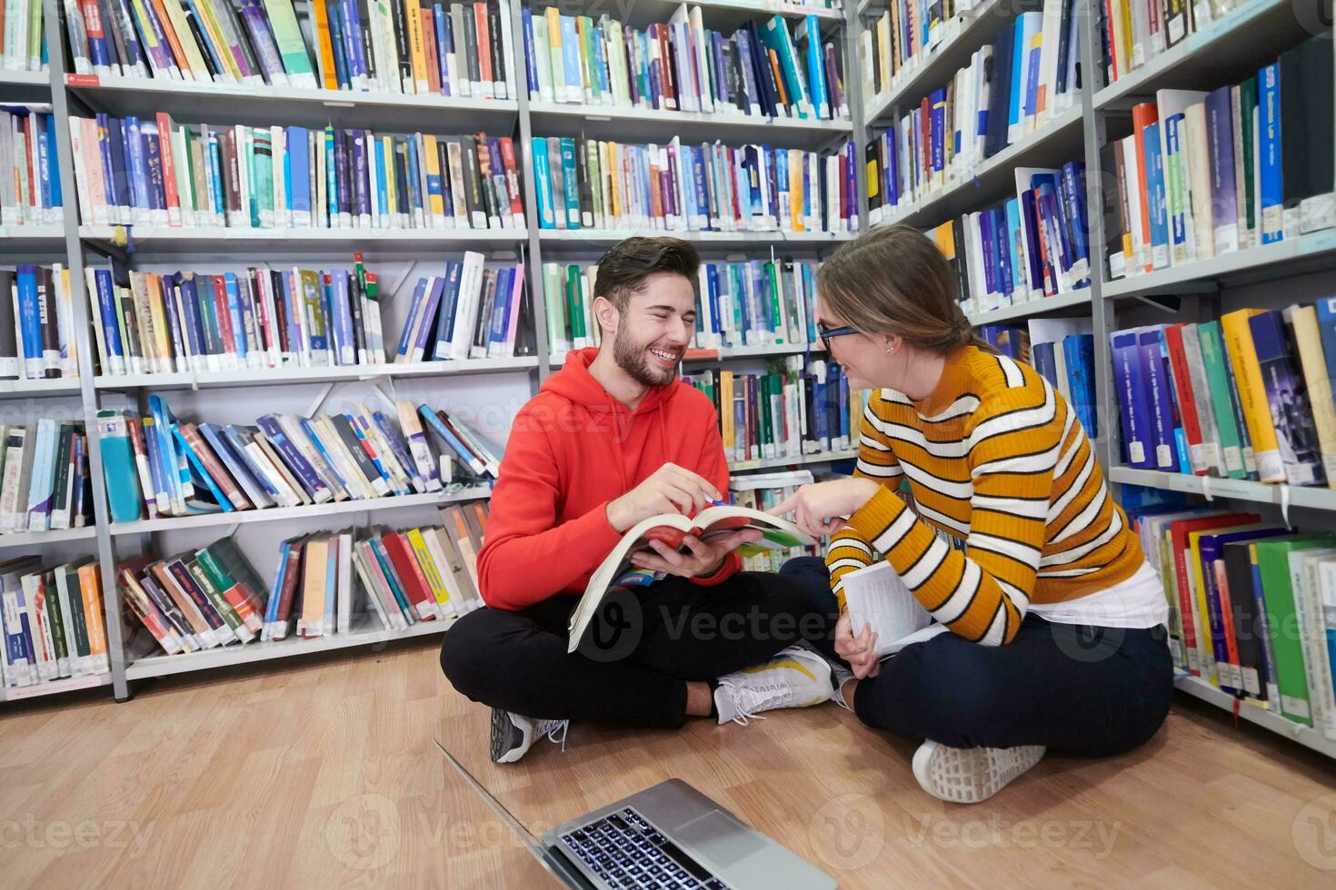 les élèves utilisent un cahier, un ordinateur portable et une bibliothèque scolaire photo