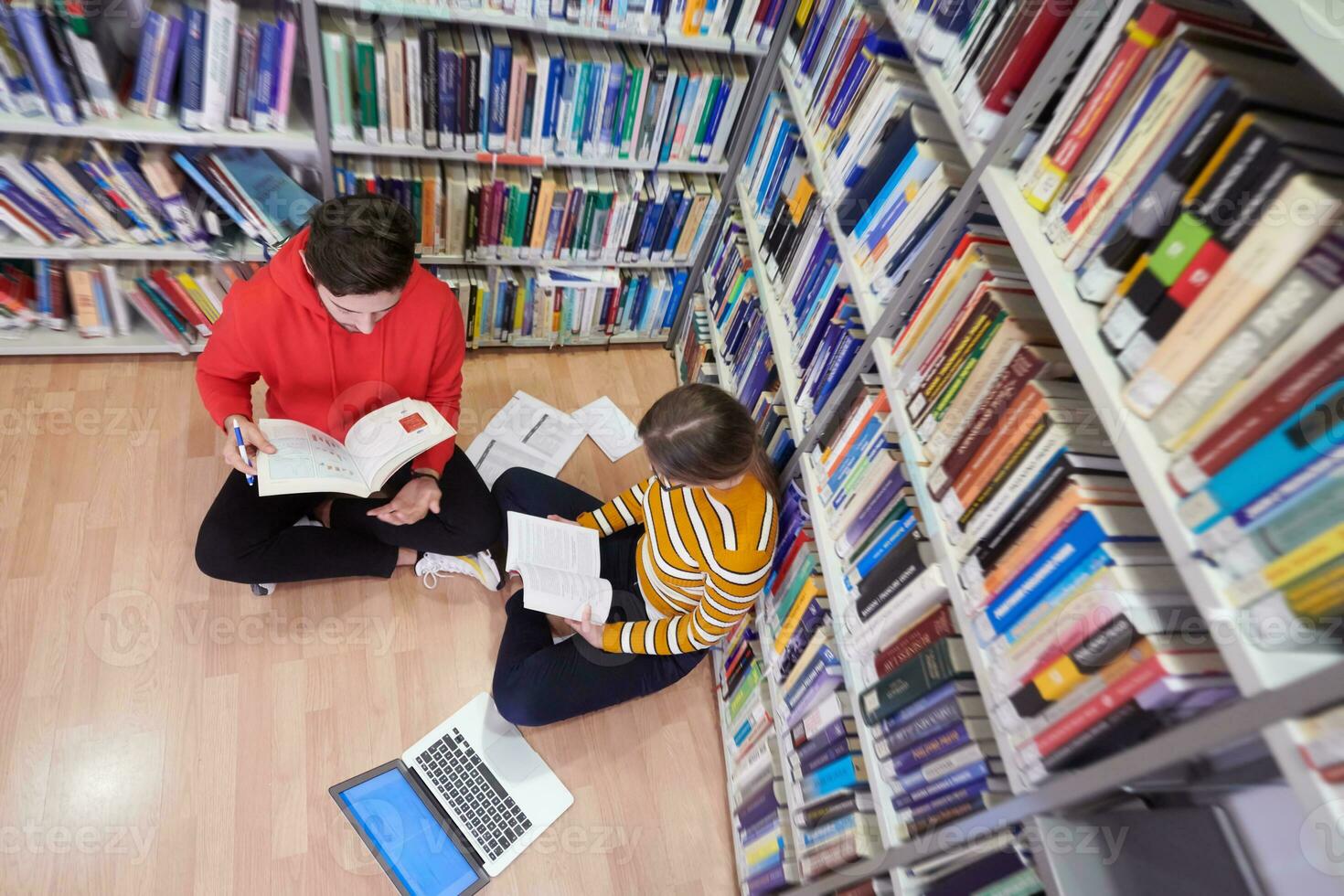 les élèves utilisent un cahier, un ordinateur portable et une bibliothèque scolaire photo