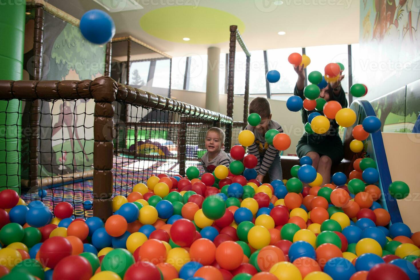 jeune maman avec ses enfants dans une salle de jeux pour enfants photo