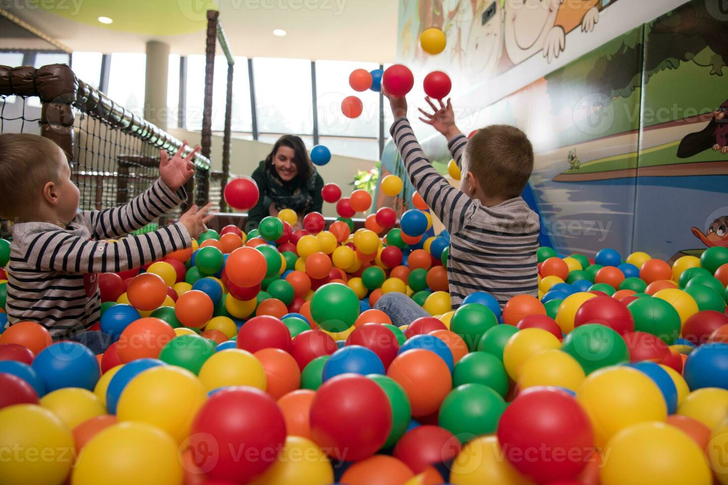 jeune maman avec ses enfants dans une salle de jeux pour enfants photo