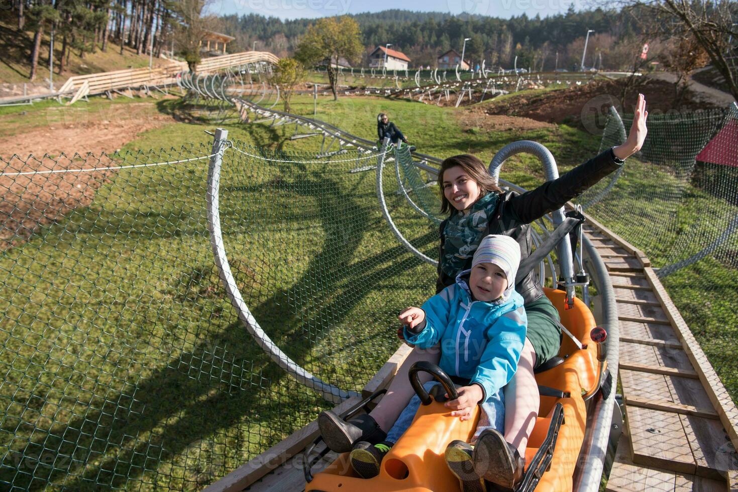 la mère et le fils aiment conduire sur les montagnes russes alpines photo