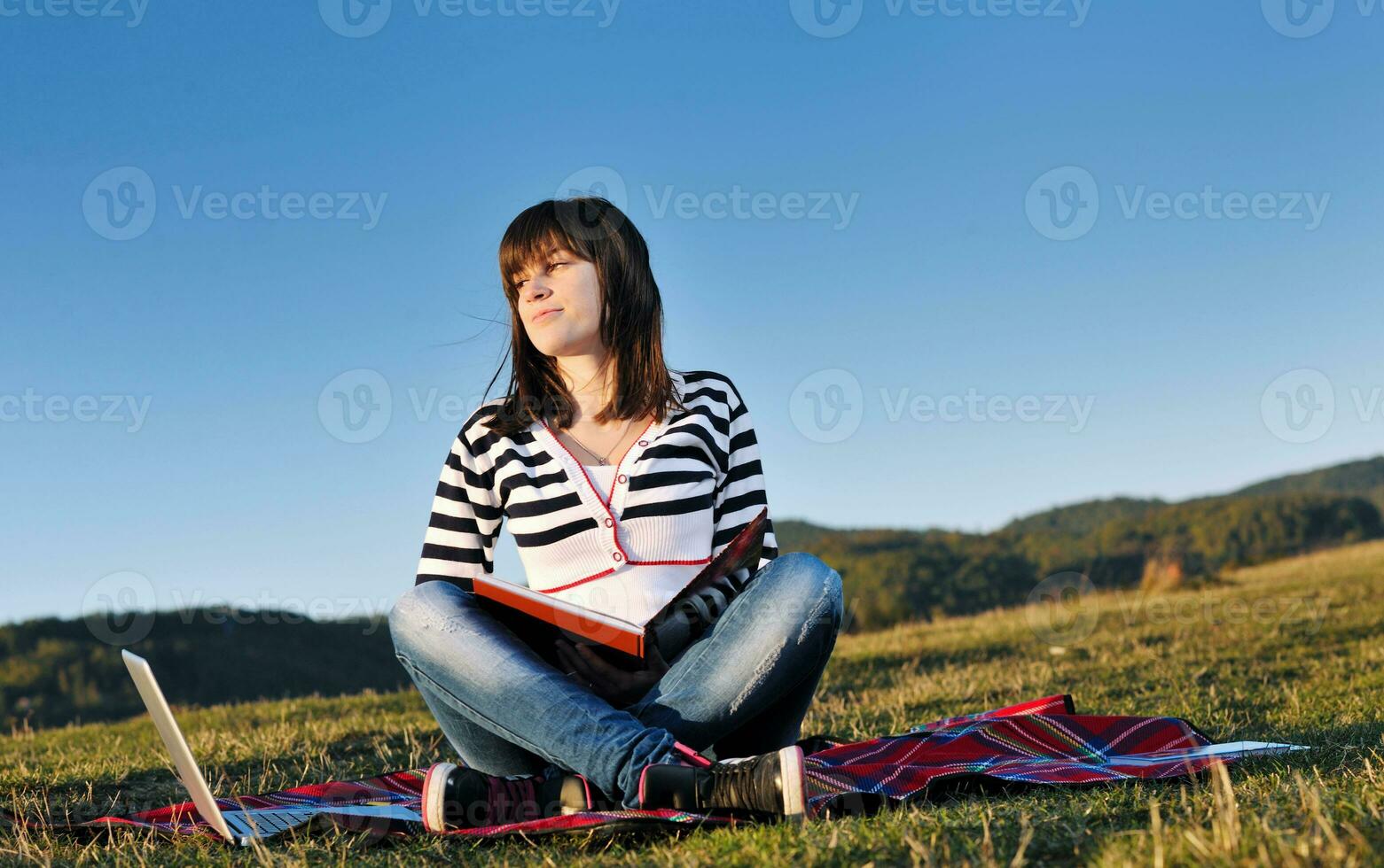 jeune adolescente travaille sur un ordinateur portable en plein air photo