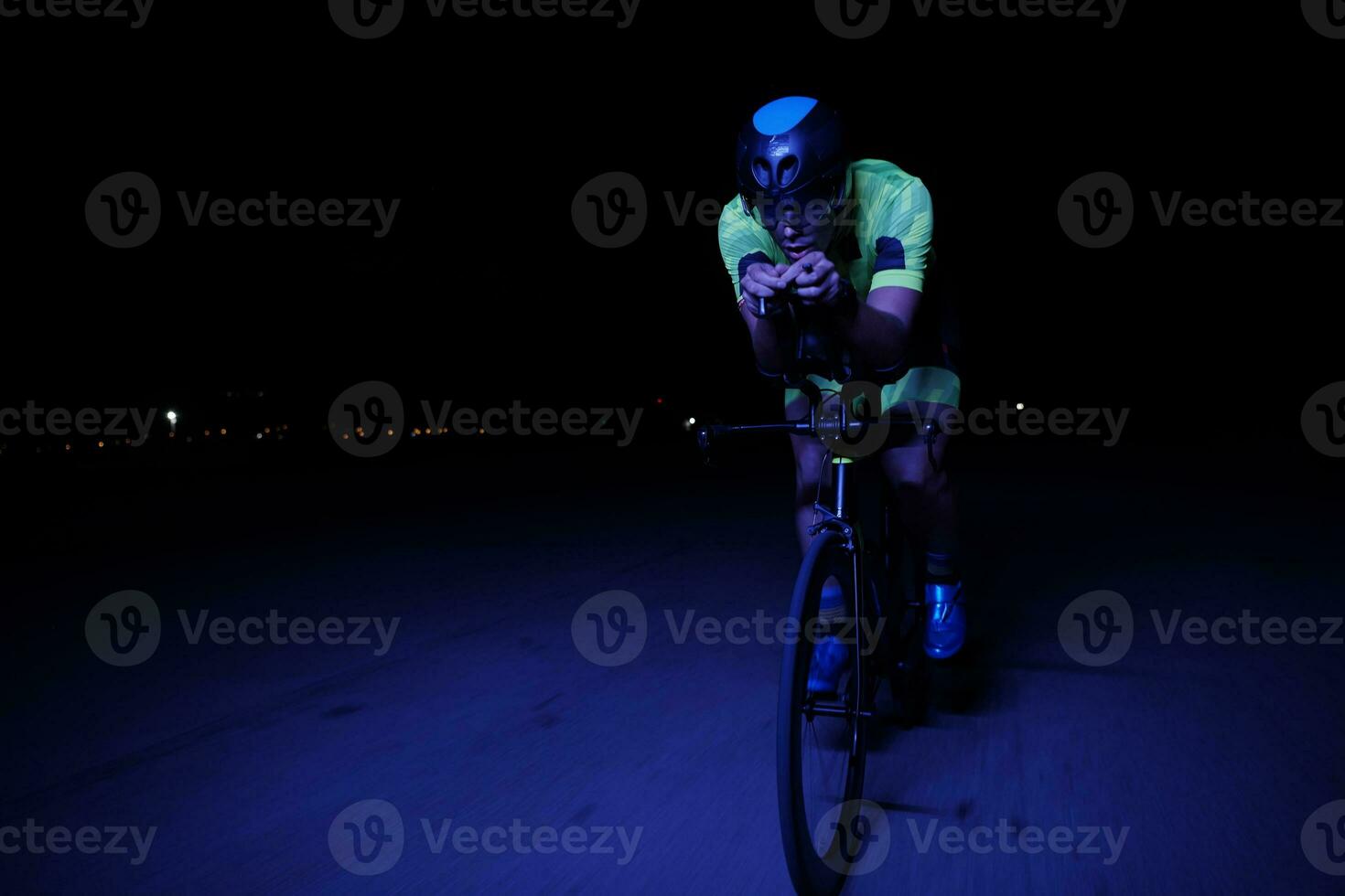 athlète de triathlon faisant du vélo rapidement la nuit photo