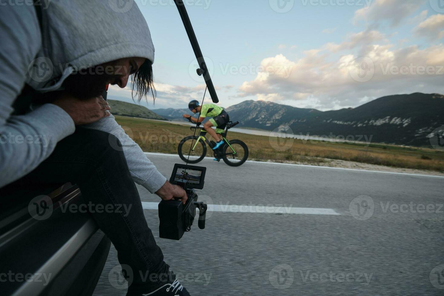directeur de la photographie prenant une photo d'action d'un athlète de vélo de triathlon