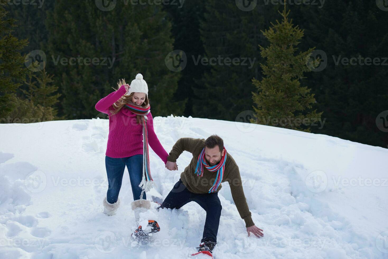 couple s'amusant et marchant en raquettes photo