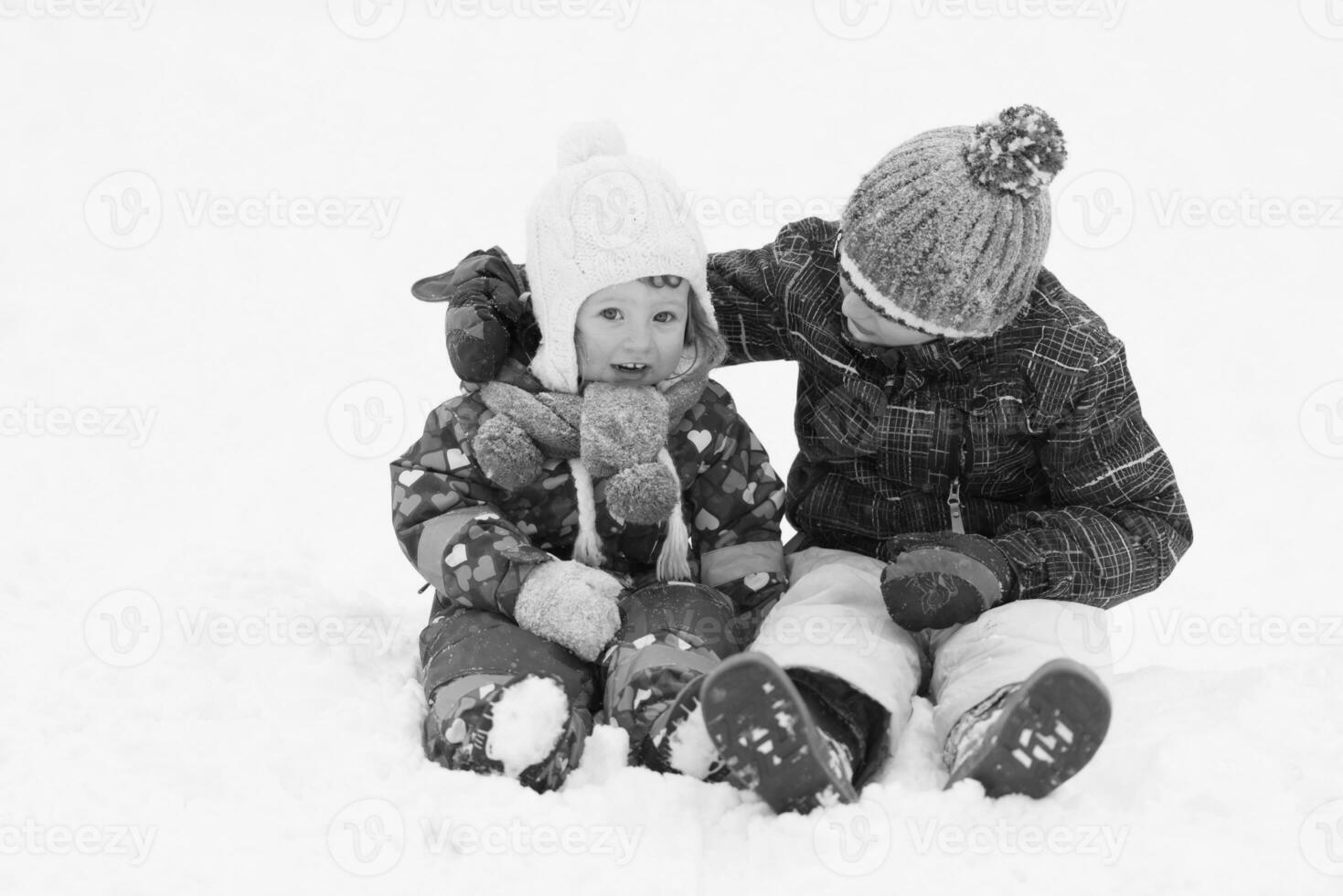 groupe d'enfants s'amusant et jouant ensemble dans la neige fraîche photo