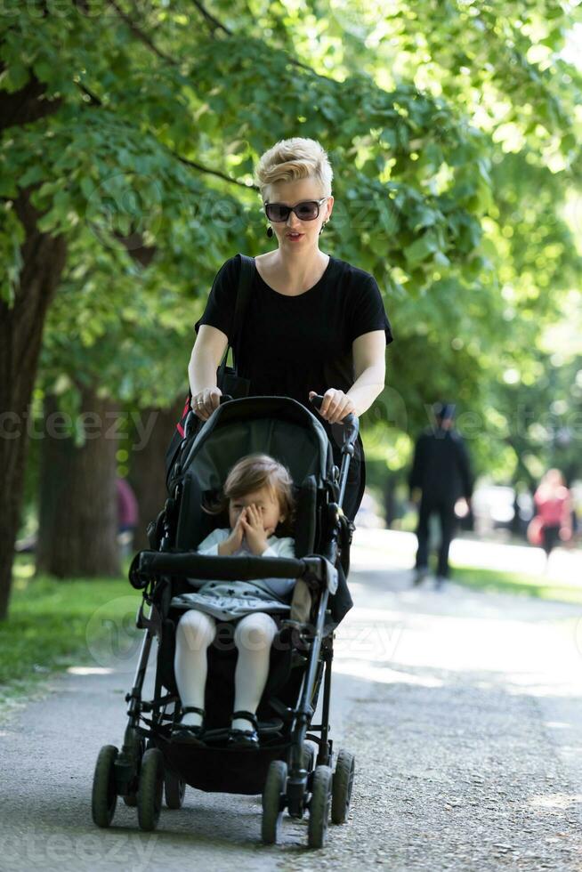 mère a poussé sa petite fille dans une poussette photo