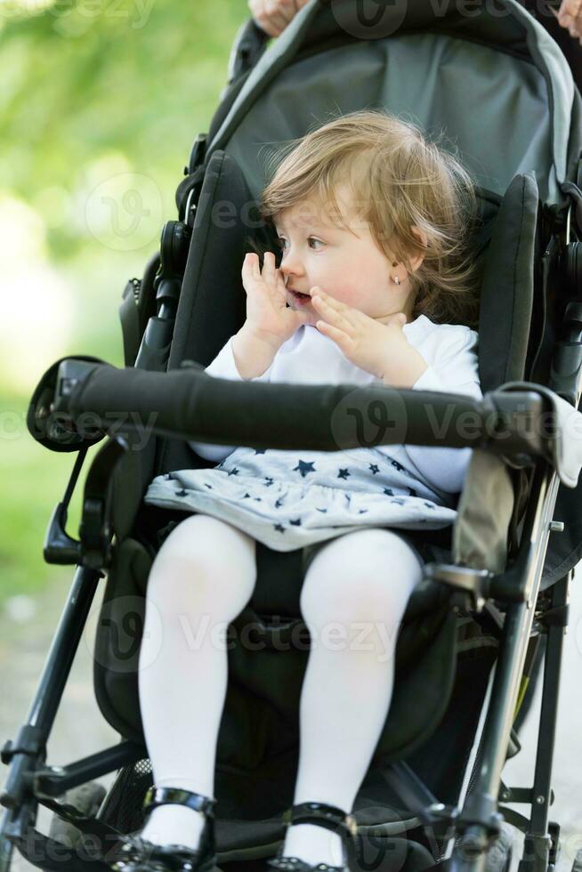 mère a poussé sa petite fille dans une poussette photo