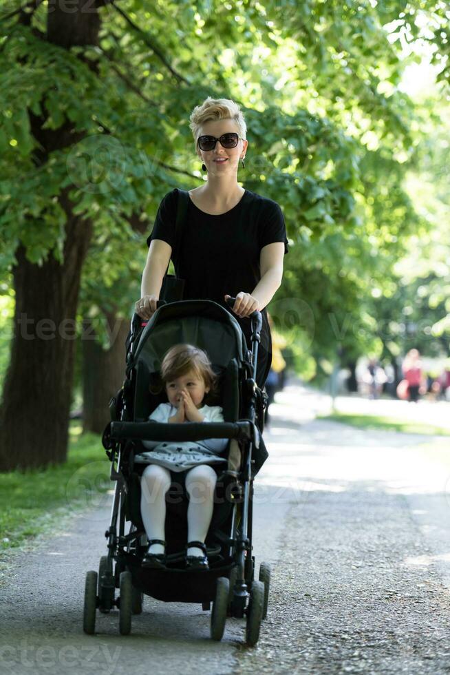 mère a poussé sa petite fille dans une poussette photo