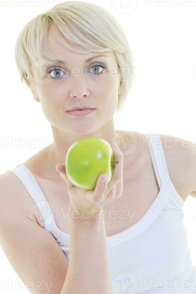 heureuse jeune femme mange une pomme verte isolée sur blanc photo